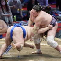 Ozeki Terunofuji tosses Hokutofuji to the dirt on the fourth day of the Nagoya Grand Sumo Tournament on Thursday. | KYODO