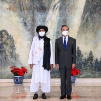 Chinese Foreign Minister Wang Yi meets with Mullah Abdul Ghani Baradar, political chief of Afghanistan's Taliban, in Tianjin, China, on July 28.  | XINHUA / VIA REUTERS