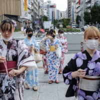 Women wearing kimonos walk toward Senso-ji Temple in Tokyo's Asakusa district this week. | REUTERS