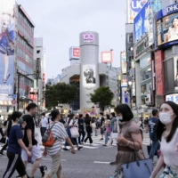 People walk across the scramble crossing in Tokyo's Shibuya district on Thursday. | KYODO