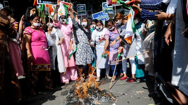 Members of the Congress women's wing burning effigy of Prime Minister Narendra Modi and Delhi Chief Minister Arvind Kejriwal to protest against alleged rape, murder and forceful cremation Backward classes of a 9 year old girl, in Delhi on Sunday Evening