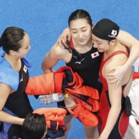 From left: Chihiro Igarashi, Rikako Ikee and Kanako Watanabe following the final of the women's 4x100 meter medley on Sunday. | KYODO