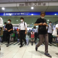 Commuters exit Fukuoka Station in the city of Fukuoka on Friday morning. | KYODO