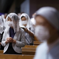 Worshipers pray during a Mass marking the 76th anniversary of the atomic bombing of Nagasaki, at Urakami Cathedral in the theater early Monday. | KYODO