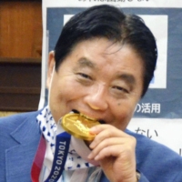 Nagoya Mayor Takashi Kawamura came under fire for putting an Olympian's medal between his teeth to pose for photos. | KYODO