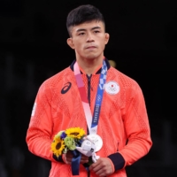 JAPAN'S KENICHIRO FUMITA POSES ON THE PODIUM WITH HIS WITH THEIR SILVER MEDAL MEDAL AFTER THE MEN'S GRECO-ROMAN 60KG WRESTLING FINAL MATCH DURING THE TOKYO 2020 OLYMPIC GAMES AT THE MAKUHARI MESSE IN TOKYO ON AUGUST 2, 2021. (PHOTO BY JACK GUEZ / AFP)