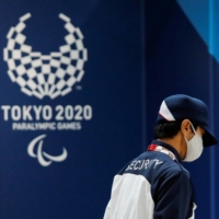 A security officer walks past a logo for the Tokyo 2020 Paralympic Games in Tokyo on Monday. | REUTERS