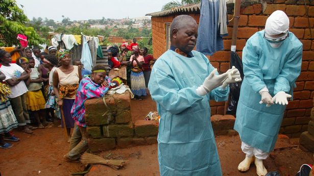 WHO officials examine the home of a suspected Marburg virus victim in the northern Angolan town of Uige April 19, 2005