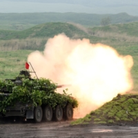 A combat vehicle fires ammunition during a live fire exercise at the Ground Self-Defense Force's training grounds in the East Fuji Maneuver Area in Gotemba, Shizuoka Prefecture, in May.   | POOL / VIA REUTERS