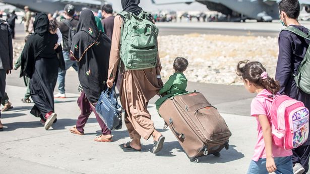 A handout photo made available by the US Marine Corps via DVIDS showing a child looks at the aircraft as he is strolled towards his flight during an evacuation at Hamid Karzai International Airport, Kabul, Afghanistan