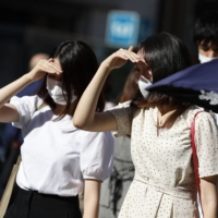 People walk in Tokyo's Ginza shopping district. Tokyo logged 235 new cases on Sep. 24, but numbers continue to drop. | KYODO