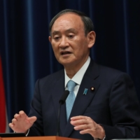 Prime Minister Yoshihide Suga speaks during a news conference earlier this month in Tokyo. Suga is expected to make a final decision next Tuesday on lifting the coronavirus state of emergency. | REUTERS / VIA BLOOMBERG