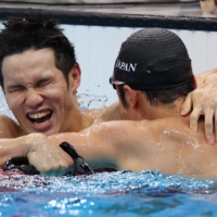 Keiichi Kimura celebrates with teammate Uchu Tomita following the S11 men's 100-meter butterfly final.  | REUTERS