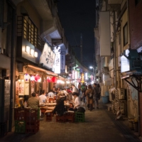 Customers dine in the outdoor section of a restaurant on the Ameyoko shopping street in Tokyo on Sunday. | BLOOMBERG