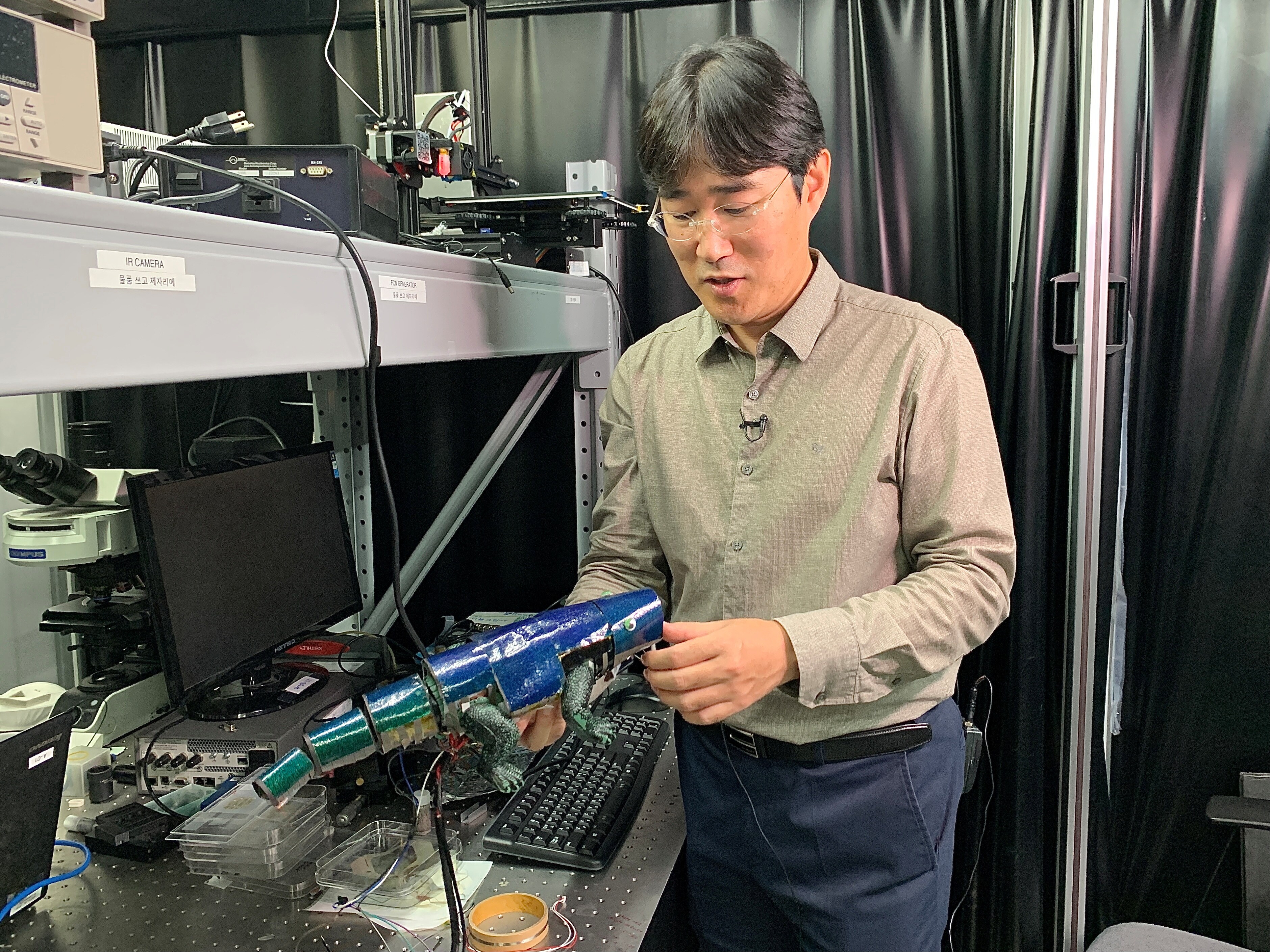 Ko Seung-hwan looks at a chameleon robot covered with artificial skin. (Reuters Photo)