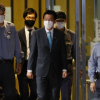 Lower House lawmaker Tsukasa Akimoto (center) leaves the Tokyo Detention House on Tuesday after being released on bail. | KYODO