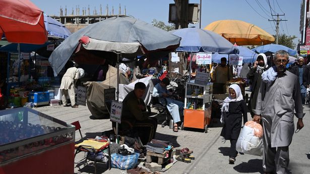 People walk along a market at Kot-e Sangi area in Kabul on September 8, 2021