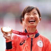 Misato Michishita celebrates on the podium after winning gold in the women's T12 marathon at the 2020 Tokyo Paralympics on Sunday. | REUTERS