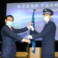 Then-Defense Minister Taro Kono (left) attends a ceremony in Tokyo in May 2020 to mark the launch of the Air Self-Defense Force's space unit tasked with monitoring space debris, asteroids and other threats to artificial satellites. | POOL / VIA KYODO
