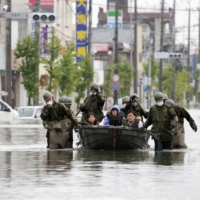 Japanese Self-Defense Force soldiers rescue local residents after heavy flooding in Omuta, Fukuoka Prefecture, in July 2020.  | KYODO
