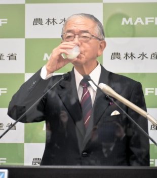 Agriculture Minister Genjiro Kaneko drinks milk on Dec. 17 as part of a campaign to raise consumption to avert discarding it. | KYODO