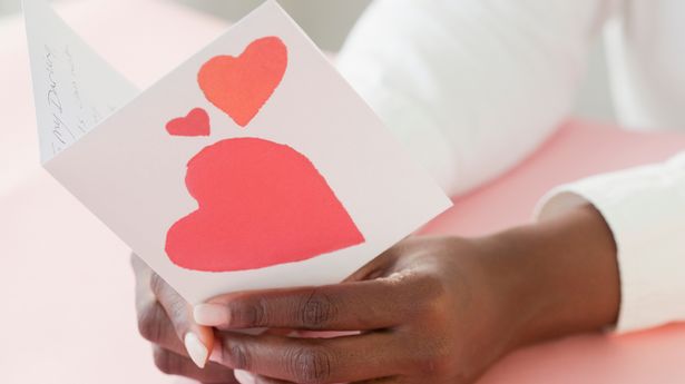 A woman opening a traditional Valentine's Day card