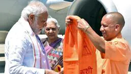 Uttar Pradesh chief minister Yogi Adityanath welcomes Prime Minister Narendra Modi on his arrival in Varanasi as governor Anandiben Patel looks on. (ANI PHOTO)