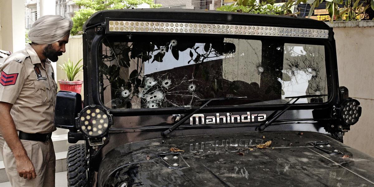 A policeman looking at the bullet marks on the vehicle of Sidhu Moosewala in which he was gunned down, at Mansa district.