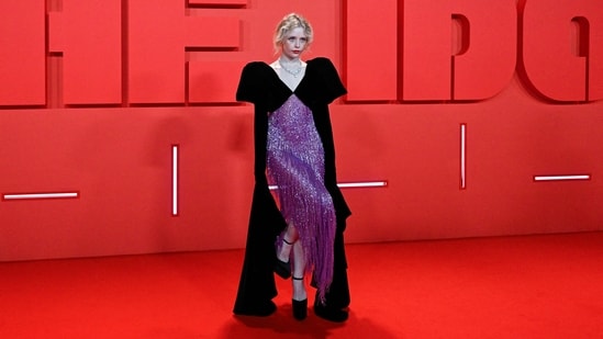 Suzanna Son chose an embellished black and purple look for the occasion. High heels, exaggerated sleeves, a statement neckpiece, and ruby-red lips rounded it off. (AFP)