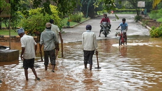 People wade through a waterlogged road after a rain shower in Bengaluru. (AFP/Image for representation)