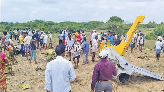 Local residents at the site where a Kiran trainer aircraft crashed, in Karnataka’s Chamarajanagar district, on Thursday. (PTI)