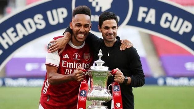 Arsenal manager Mikel Arteta and Pierre-Emerick Aubameyang celebrate with the trophy after winning the FA Cup.(Pool via REUTERS)