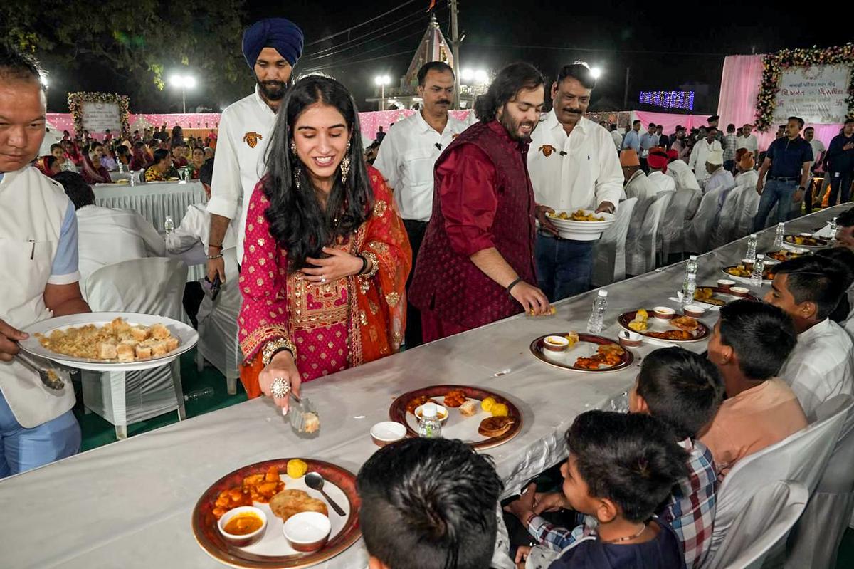 Reliance Foundation Director Anant Ambani with his fiance Radhika Merchant distribute traditional Gujarati food to villagers during Anna Seva as part of their pre-wedding function, at the Jogwad village near Reliance Township in Jamnagar on Wednesday. 