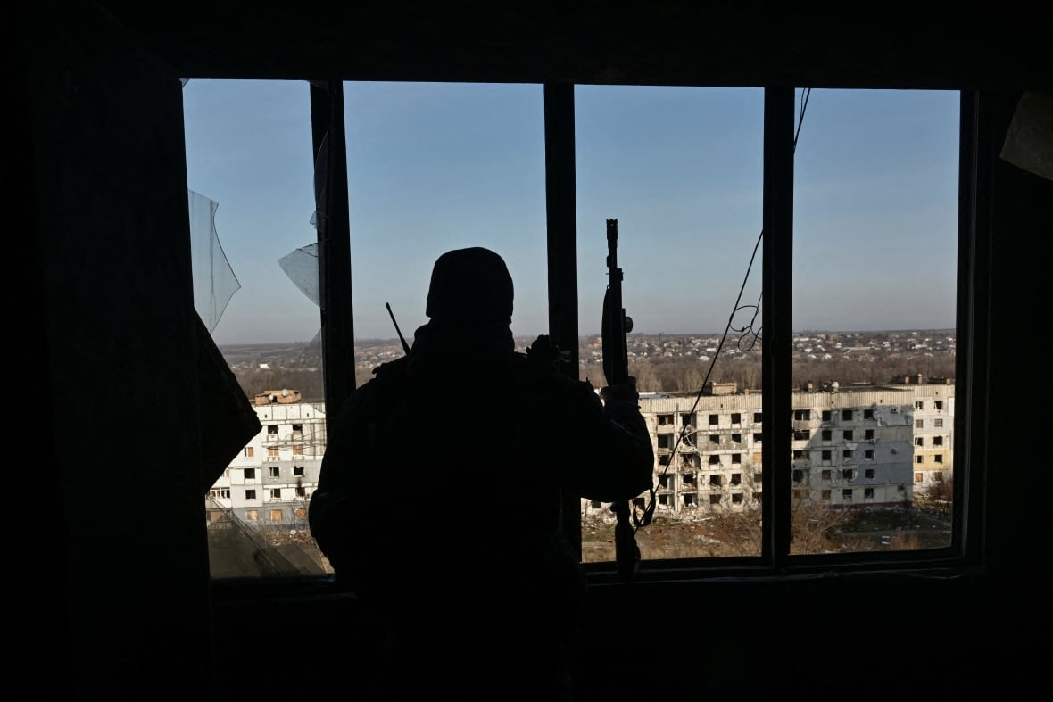 A police officer looks out from a window in Ukraine's Zaporizhzhia region.