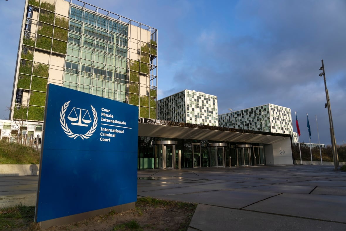 An exterior view of three connected buildings with a blue sign in front reading "International Criminal Court."