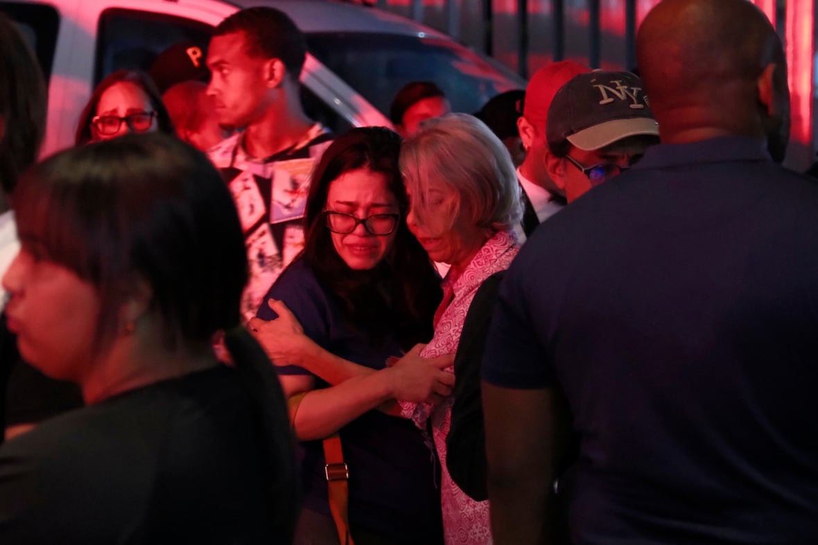 Relatives of missing people embrace.