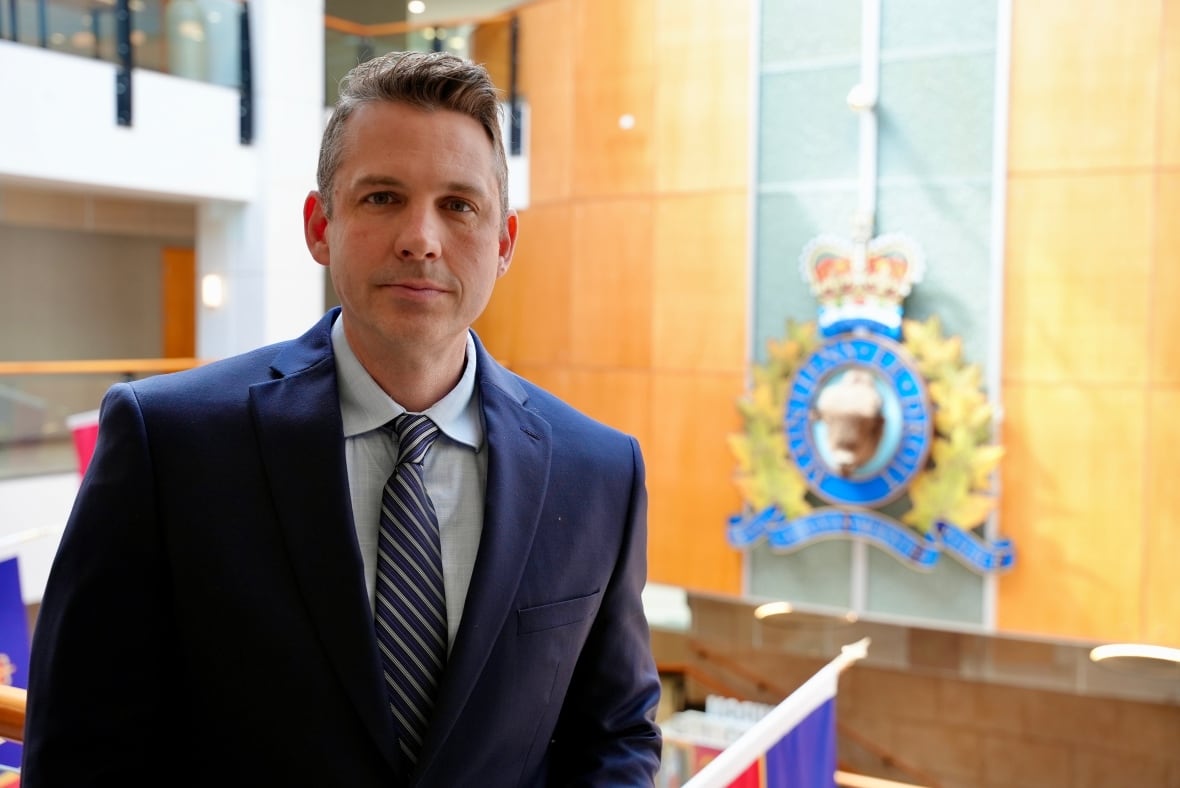Man in a suit standing in the atrium of RCMP headquarters.