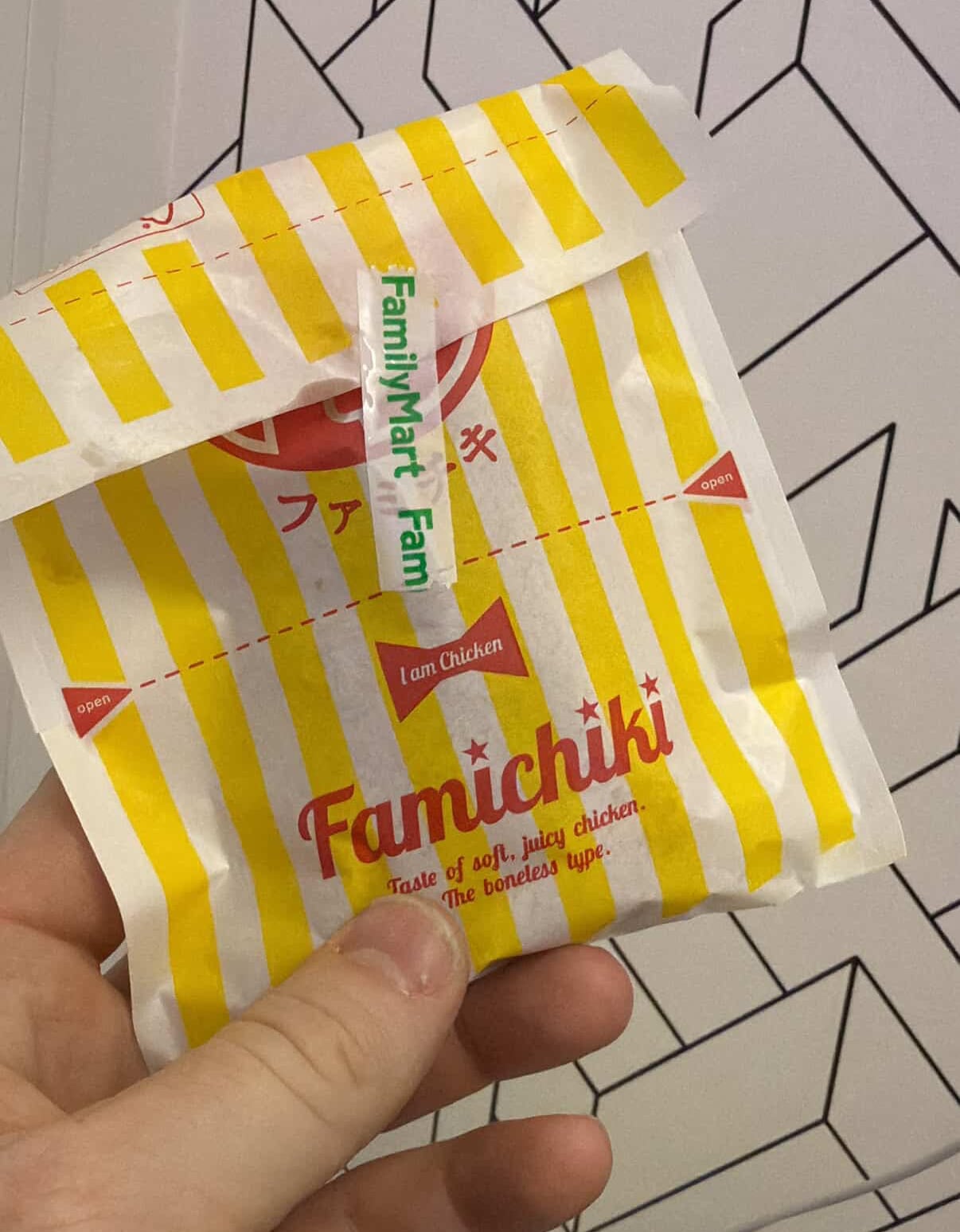 A hand holds a packet that says famichiki