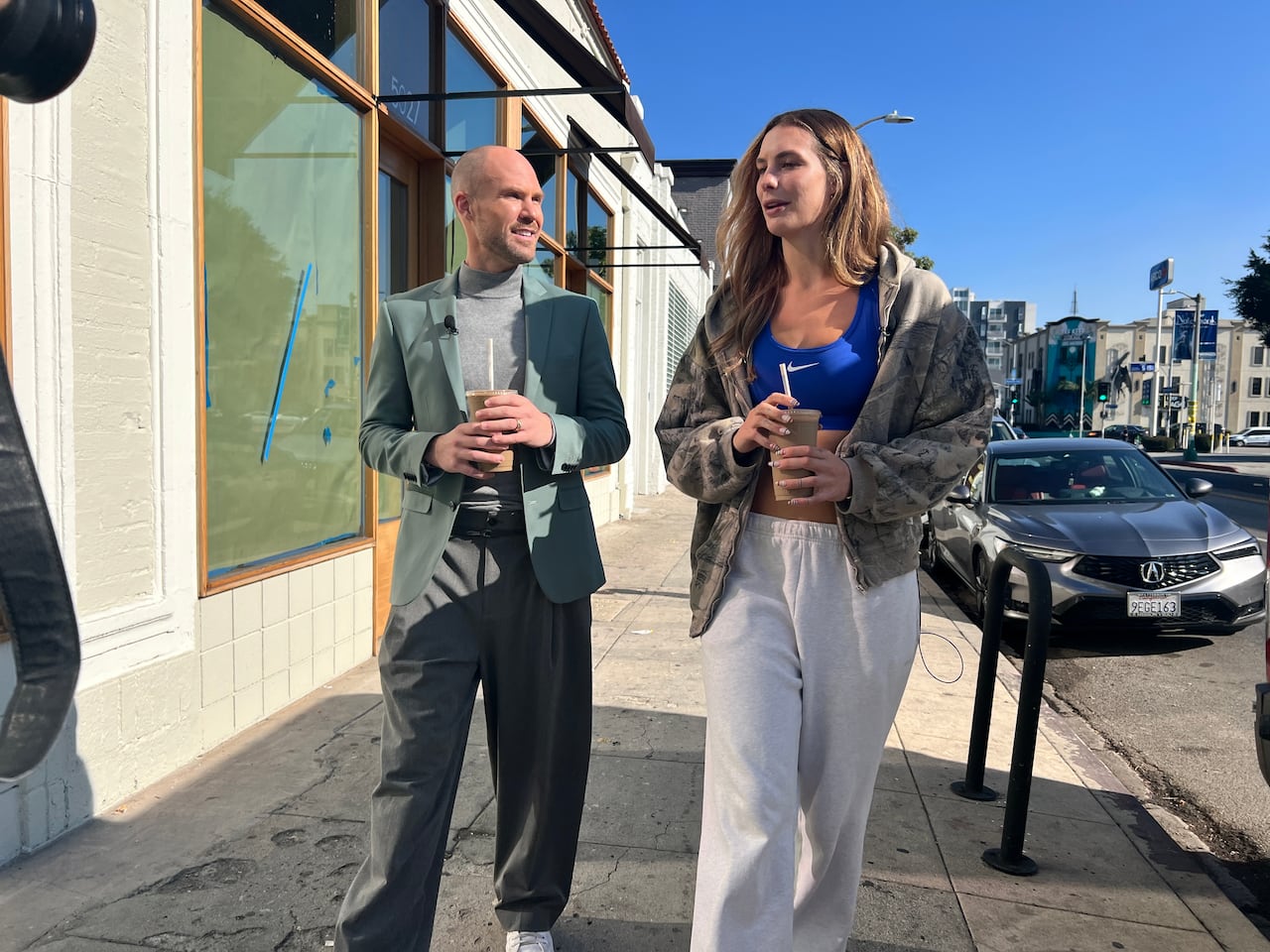 Two people walk down the street.