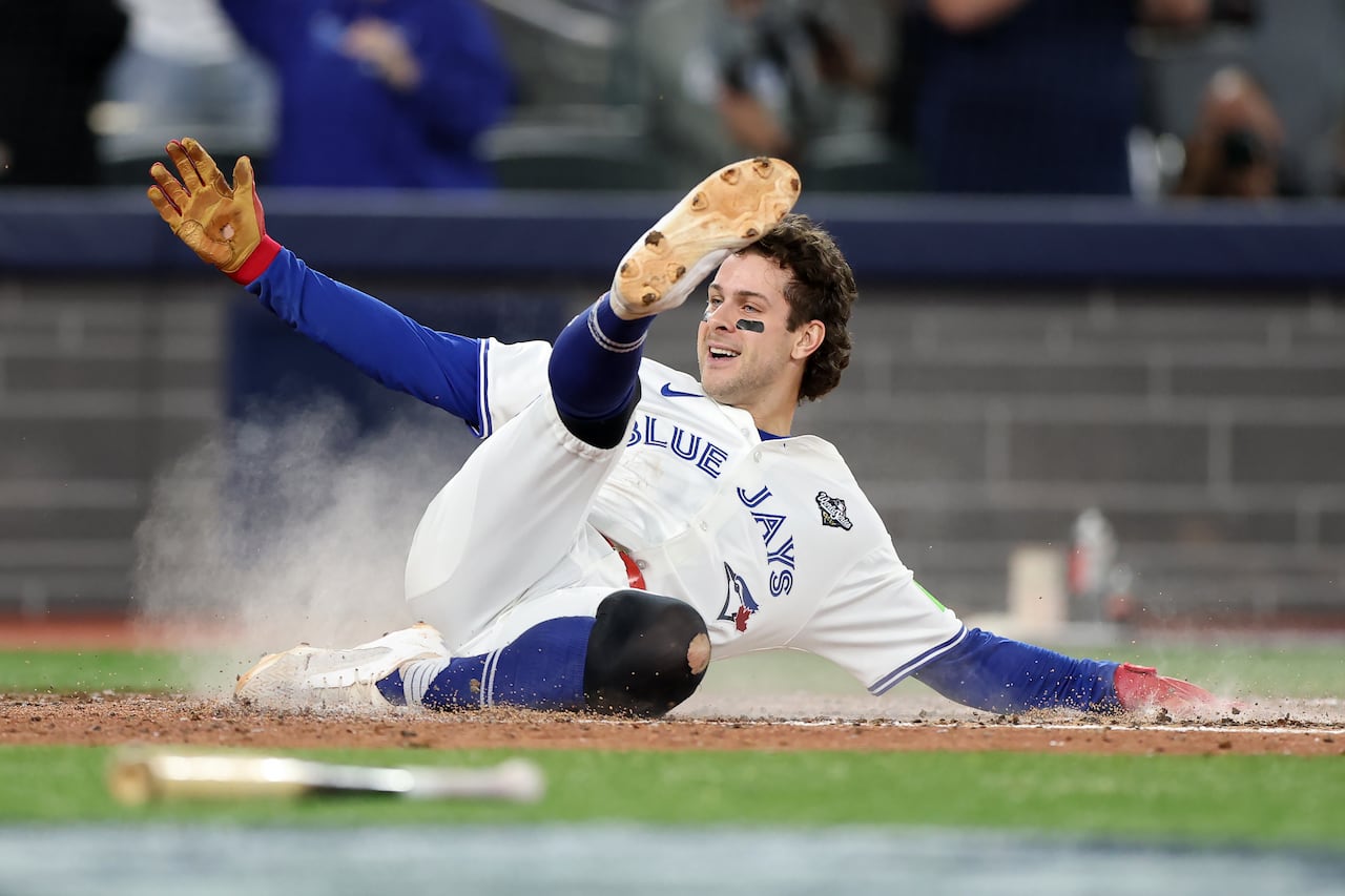 A baseball player slides into home plate.