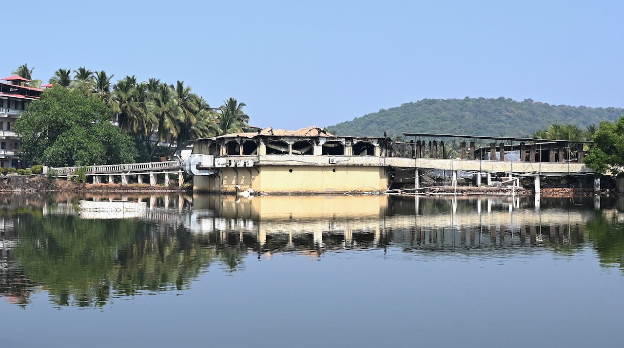 A structure over a body of water is seen charred.